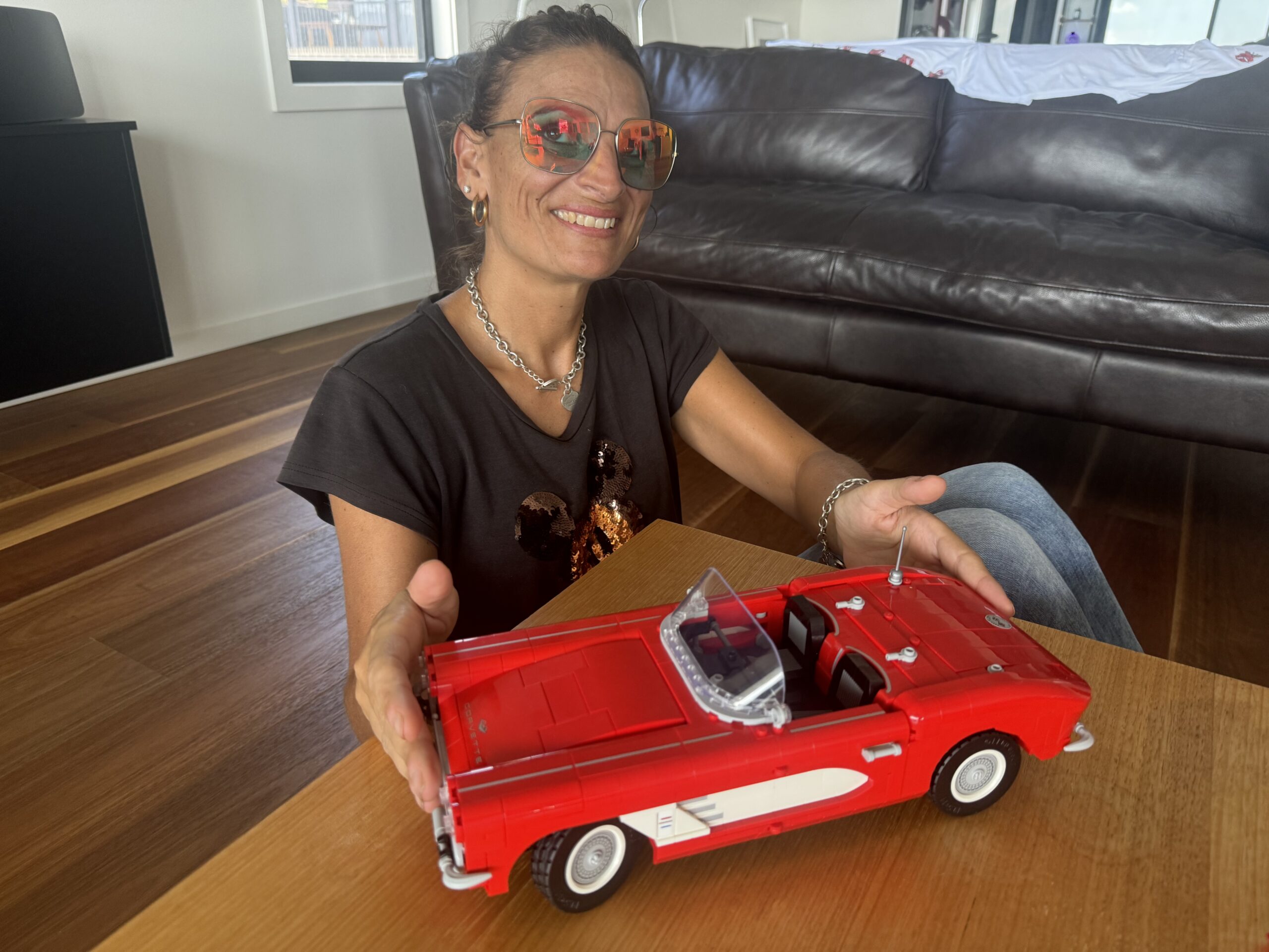 Renee, a woman wearing red shades built lego Chevrolet Corvette 1971.Renee, a woman wearing red shades built lego Chevrolet Corvette 1971.