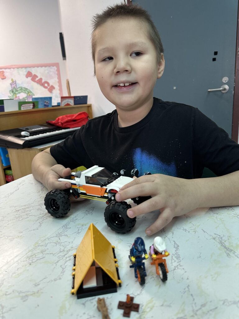 Picture of young blind child with completed LEGO build